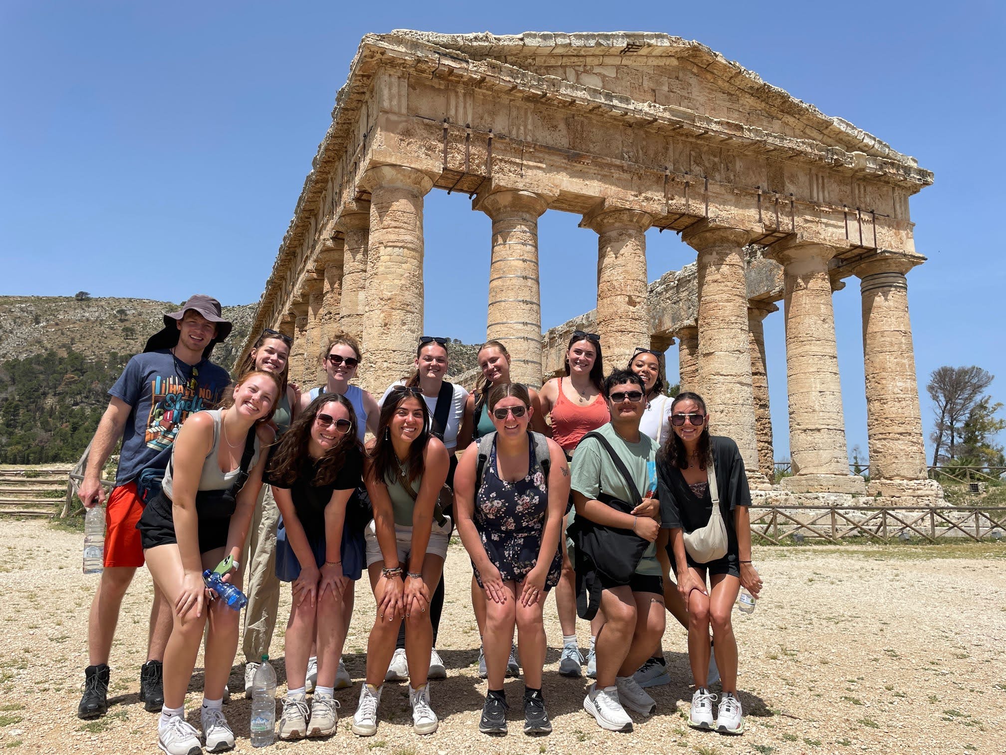 Students studying abroad pose in front of the Parthenon on the Acropolis in Athens