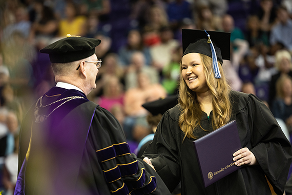 student smiling at graduation ceremony
