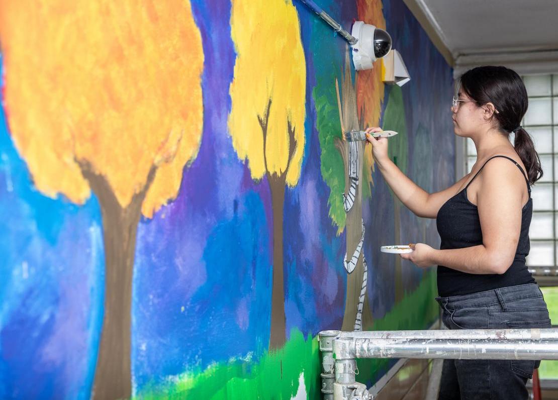 Art education students help paint a mural 