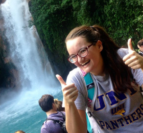 Student in Costa Rica next to Waterfall